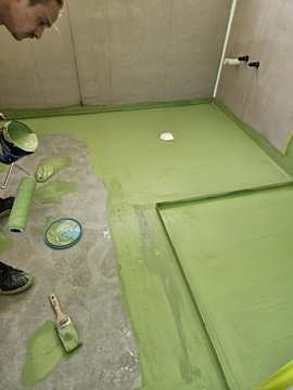 Waterproofing membrane being rolled onto a bathroom floor
