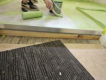Membrane being rolled across the bathroom floor and hob