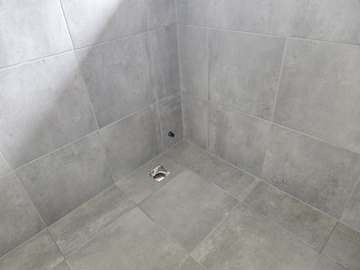Finished tiled shower recess with waste